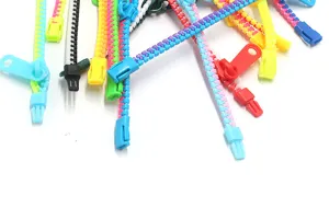 Vue détaillée de bracelets zippés en plastique coloré, montrant des liens de jouets bicolores.