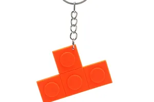 Orange PVC block keychain detail, T-shaped brick pendant showing fine soft rubber texture.
