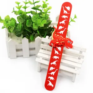 Nahaufnahme des roten Kinder Schnapparmbands mit Dinosaurier Motiven und 3D Spielzeug.