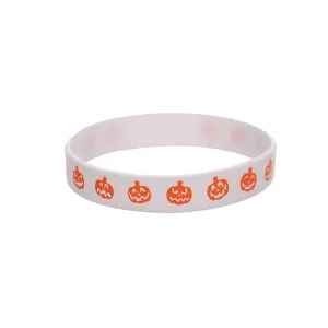 Détail de bracelet en silicone Halloween avec impression de citrouille orange sur fond blanc.