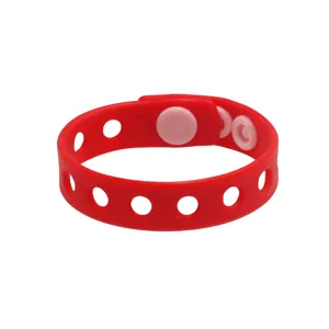 Vue détaillée du bracelet en silicone rouge montrant clairement les boutons-pression et trous.