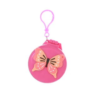 Portable folding pink hairbrush detail shot, cute butterfly design, compact mirror comb.