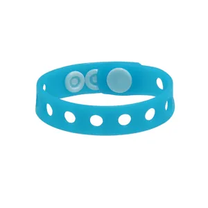 Bracelet en silicone bleu avec boutons-pression, détail de l'accessoire flexible.