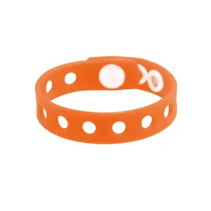 Gros plan détaillé du bracelet troué en silicone orange, idéal pour breloques et accessoires.