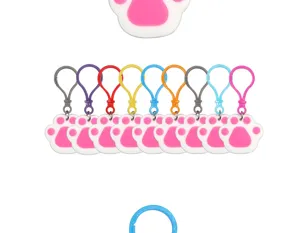 Close up of colorful silicone paw print keychains with vibrant plastic hooks for parties.