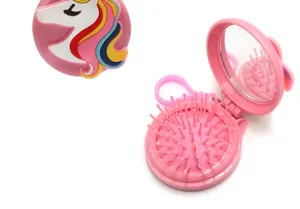 Gros plan sur la brosse à cheveux de poche pliable portable avec miroir et design licorne.