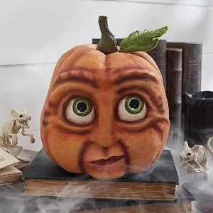 Detailed view of the quirky human face pumpkin resin ornament with spooky holiday setup.