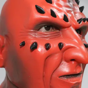 Close-up detail of red latex demon mask with black spikes, realistic texture and creepy design.