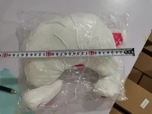 Detailed view of the white plush rabbit toy in packaging with measuring tape for sizing.