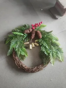 Handgemaakte kerstkrans met dennenappels en bessen, ideaal voor de feestelijke deurdecoratie.