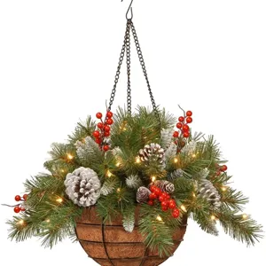 Verlichte kersthangmand met dennenappels en rode bessen voor feestelijke huisdecoratie