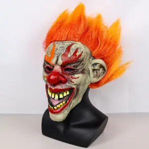 Close-up detail of scary flaming clown latex mask with vibrant orange hair for Halloween.