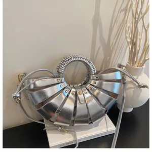 Detailansicht der eleganten silbernen Metallic-Muschel-Umhängetasche mit Ringgriff.