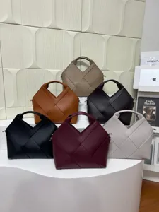 Detailed showcase of stylish woven leather tote handbags in multi colors on a white shelf.