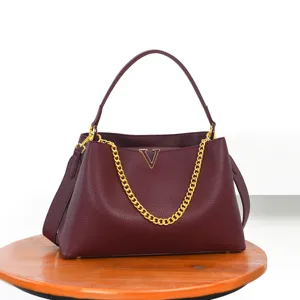 Burgundy leather handbag detail showing gold chain and metal V logo, large capacity.