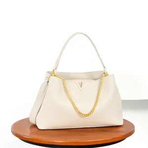Detail view of the elegant beige leather shoulder bag with chic gold chain and V logo accent.