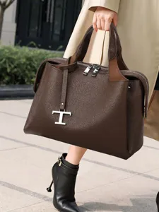 Detailaufnahme der braunen Damen Handtasche aus Narbenleder mit Metall T Anhänger, Chic.