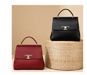 Close-up details of elegant leather handbags featuring chic metal clasp and top handle design.