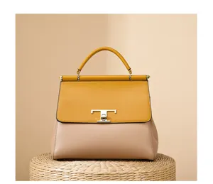 Close-up detail of a stylish two-tone leather handbag featuring chic flap and elegant metal lock.