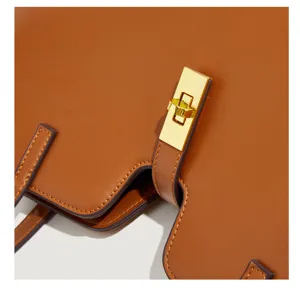 Braune leder tragetasche detailansicht mit luxus gold metall drehverschluss und nähten.