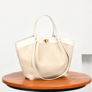 Detalle de bolso de cuero tejido, bolso tote blanco crema con cierre metalico.