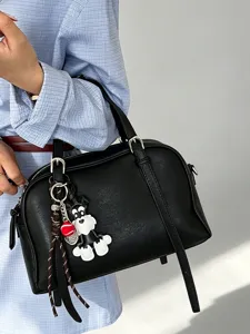 Black soft leather handbag detailed view, stylish crossbody design with cute puppy charm.
