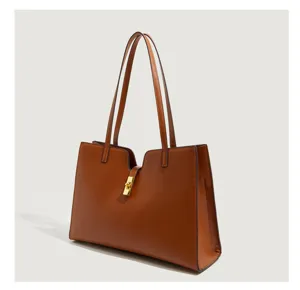 Braune Ledertasche Detailansicht mit goldenem mittigen Schloss und doppelten Schulterriemen.