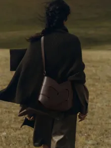 Stylish dark brown leather shoulder bag detail shot, showing unique knotted design and elegant style.
