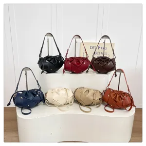 Detailed view showing multi-color woven cloud shoulder bags neatly displayed on white tiers.