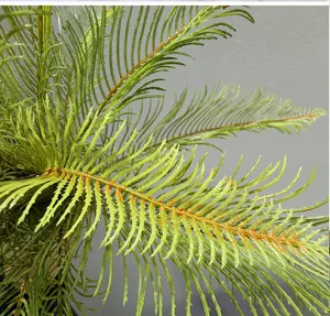Artificial fern plant detail close-up, realistic green foliage for indoor home decor landscape.