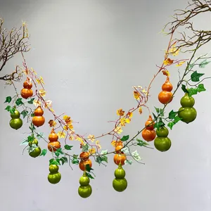 Detailed view of artificial gourd vine featuring realistic green and orange hanging gourds.