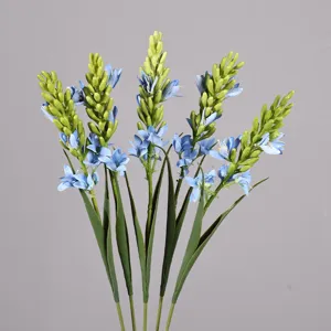 Primo piano di dettaglio del ramo di fiore artificiale blu con gemme verdi e foglie.