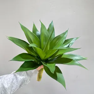 Artificial agave plant detail shot, showing realistic green leaves and stem structure.