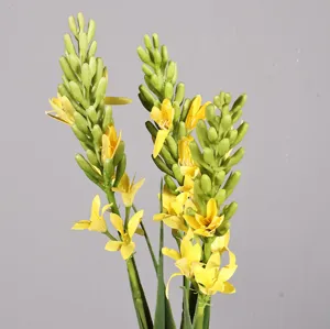Primo piano di boccioli di fiori gialli artificiali e steli verdi per la decorazione.