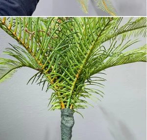 Artificial fern frond detail shot, realistic green plant branch for indoor floral arrangement