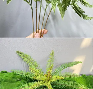 Closeup detail view of artificial green fern plant leaves and long stems for indoor decor.