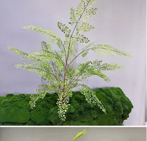 Artificial fern plant detail, fake boston fern green foliage with moss base for decor.