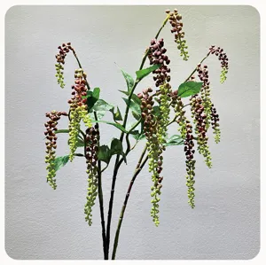 Dettaglio ramo pianta artificiale pendente, decorazione con bacche verdi e viola.