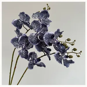 Vue rapprochée d'une branche d'orchidée artificielle violette tachetée avec des bourgeons.