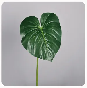 Gedetailleerd close-up van een levendig groen kunstplantblad met realistische textuur thuis.