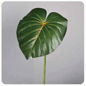 Gedetailleerde opname van kunstblad, groen loof met gele aderen, realistische plantenversiering.