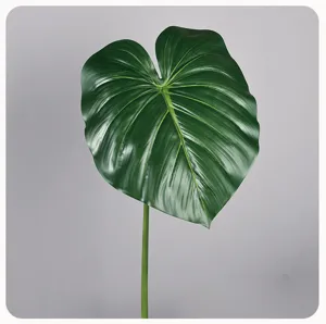 Detailopname van een levendig groen kunstplantblad met realistische textuur en steel.