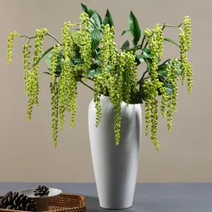 Pianta artificiale sospesa bacche verdi in vaso ceramica bianca decorazione principale.
