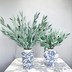 Kunstmatige olijftakken met vruchten in blauw witte keramiek vazen voor interieur decoratie