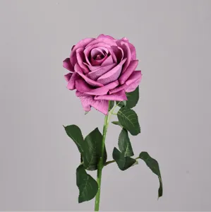 Primo piano dettagliato di una rosa artificiale con foglie verdi realistiche per decorazione.