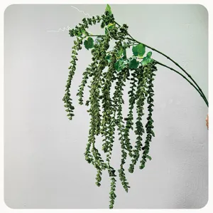 Detalle de planta artificial colgante, hermosa guirlanda de bayas verdes para decorado.