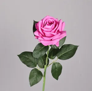 Primo piano dettagliato del fiore di rosa artificiale con foglie verdi per decorazione.