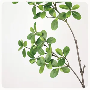 Artificial green plant branch detail shot, lifelike terminalia leaves with natural texture for home decor.