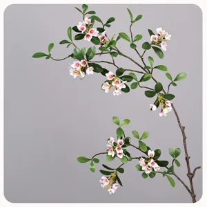 Artificial plant branch detail shot, realistic pink flowers and green leaves for home decoration.