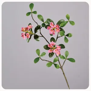 Detailed close-up of artificial pink flower branch with green leaves, realistic plant decor.